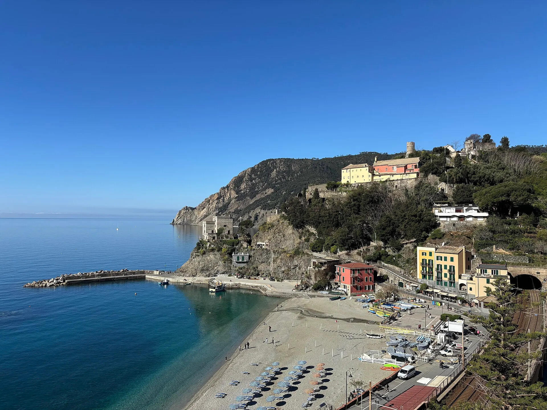 Monterosso al Mare in the Cinque Terre — the sandy beach below the village, with the headland and old watchtower.