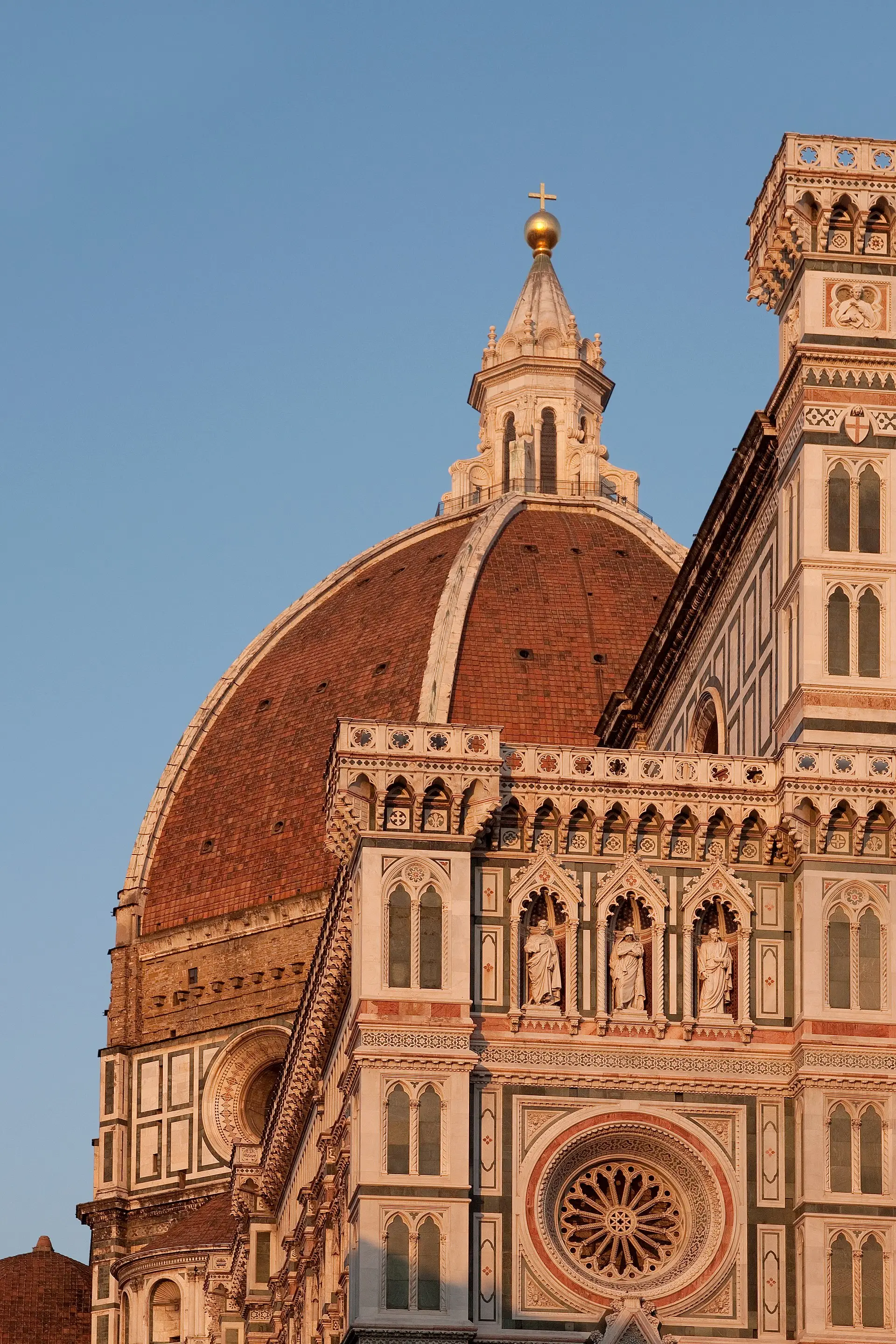 Florence Cathedral at sunset — Brunelleschi's terracotta dome and the gold-lit marble Gothic facade.