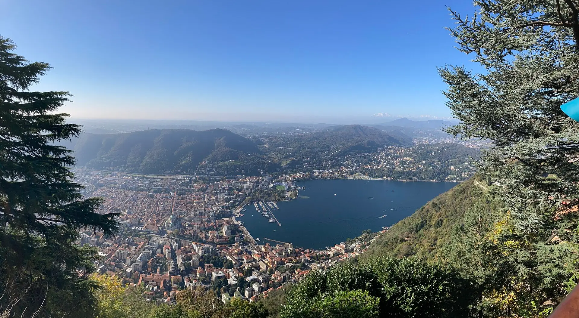 Panorama from Brunate above Como — the city, the lake's southern basin, and the surrounding hills.