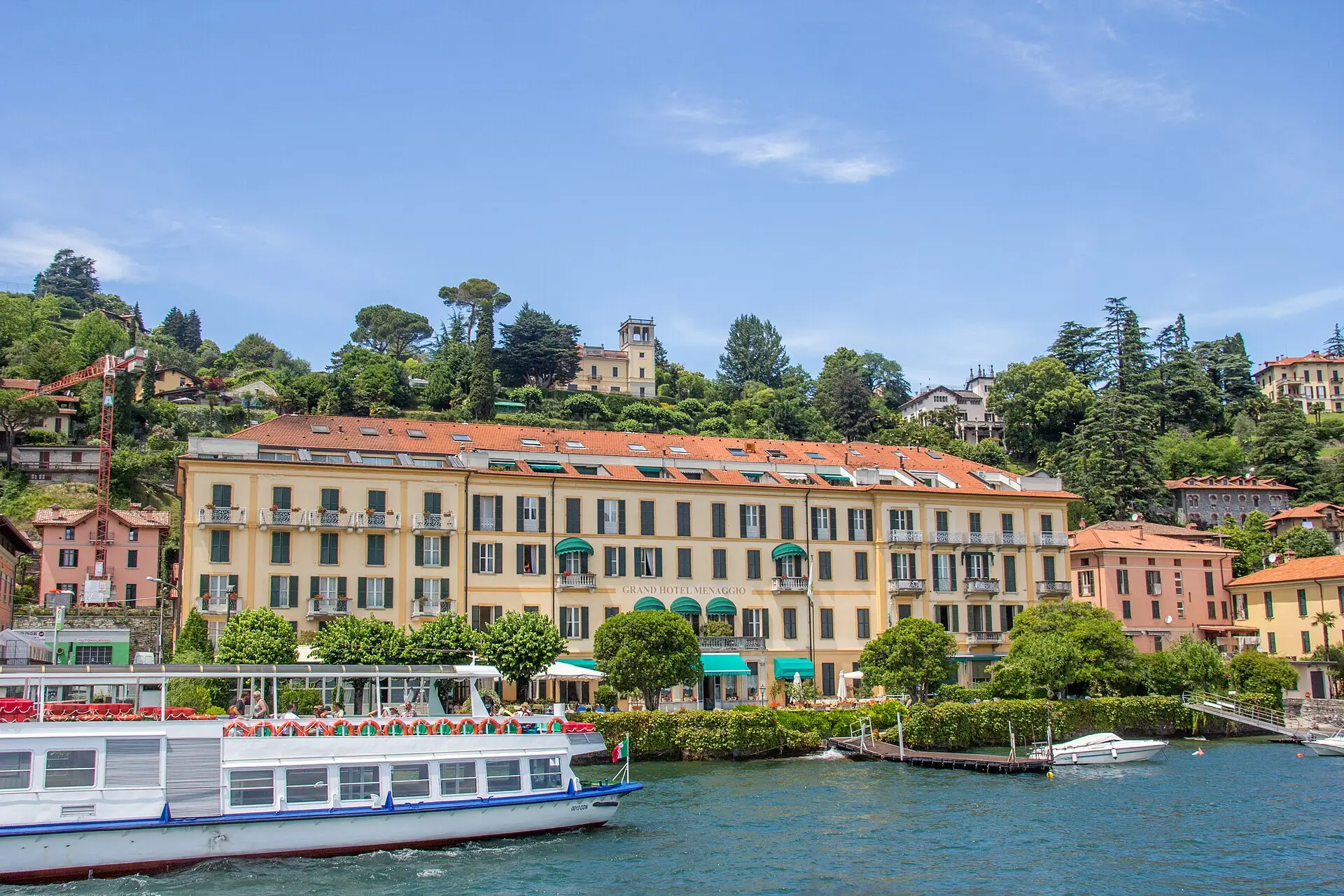 Menaggio waterfront on the western shore of Lake Como — long Italianate hotel and lakeside buildings.