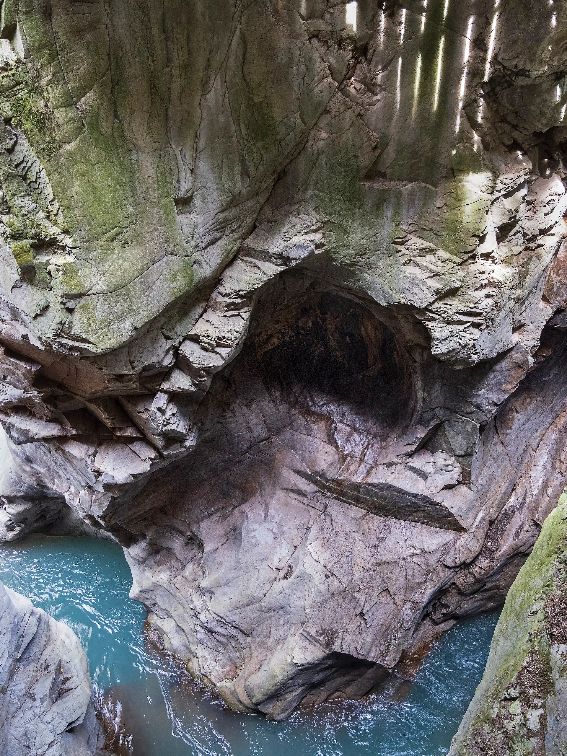 Orrido di Bellano — a dramatic limestone gorge with smooth water-carved walls and a turquoise river at the bottom.