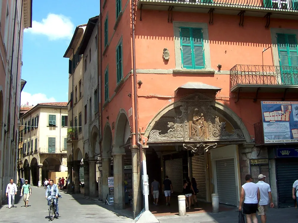 Borgo Stretto in Pisa — the arcaded medieval shopping street with terracotta-and-yellow facades.